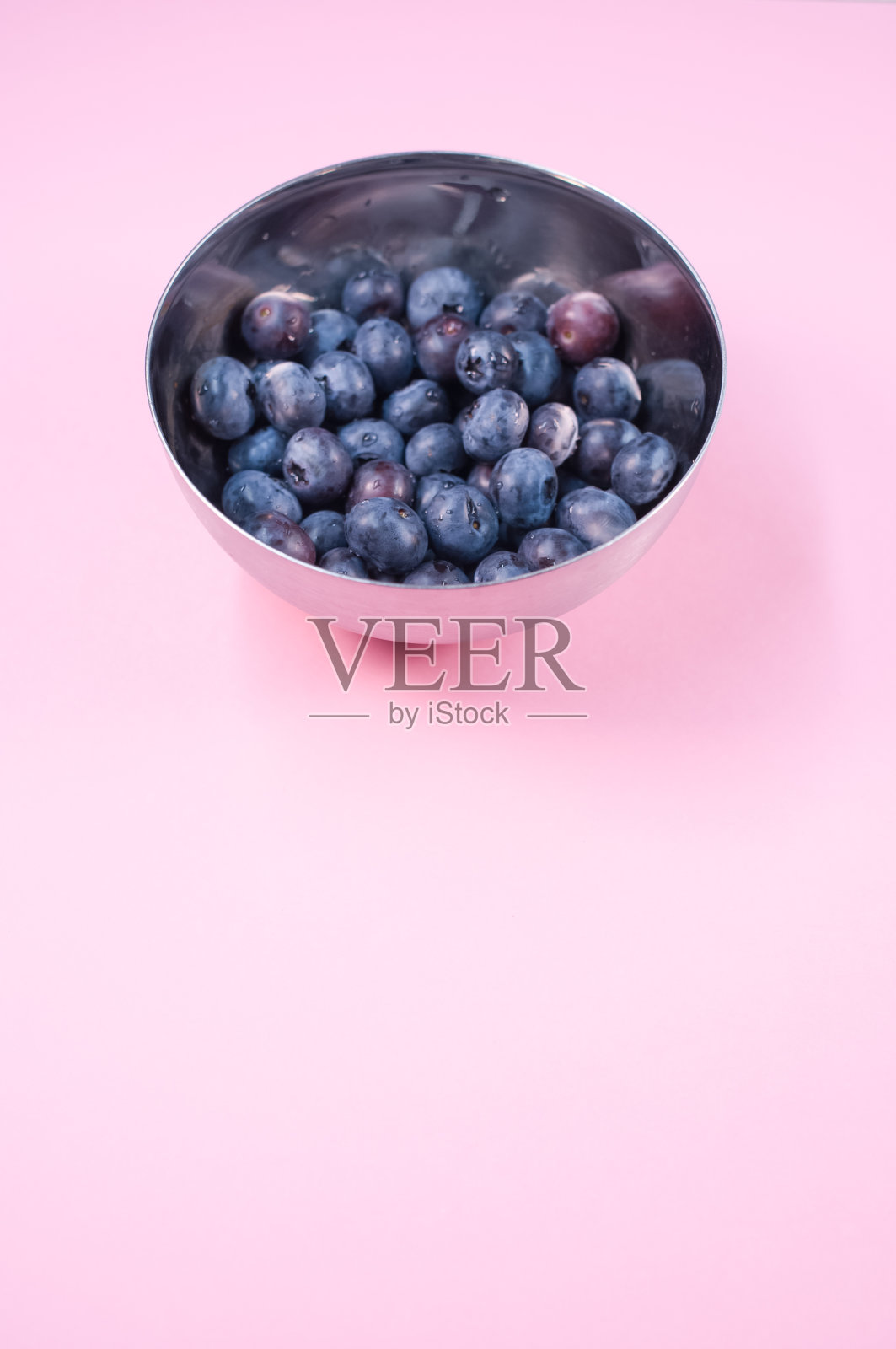 浅粉色背景上的蓝莓垂直镜头照片摄影图片