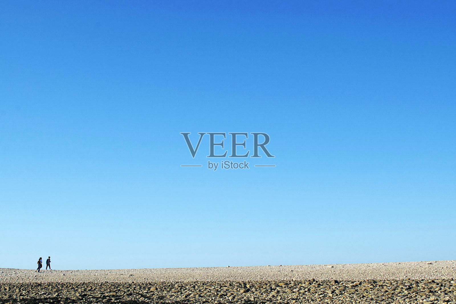 在一个晴朗的日子里，人们站在荒芜的田野里照片摄影图片