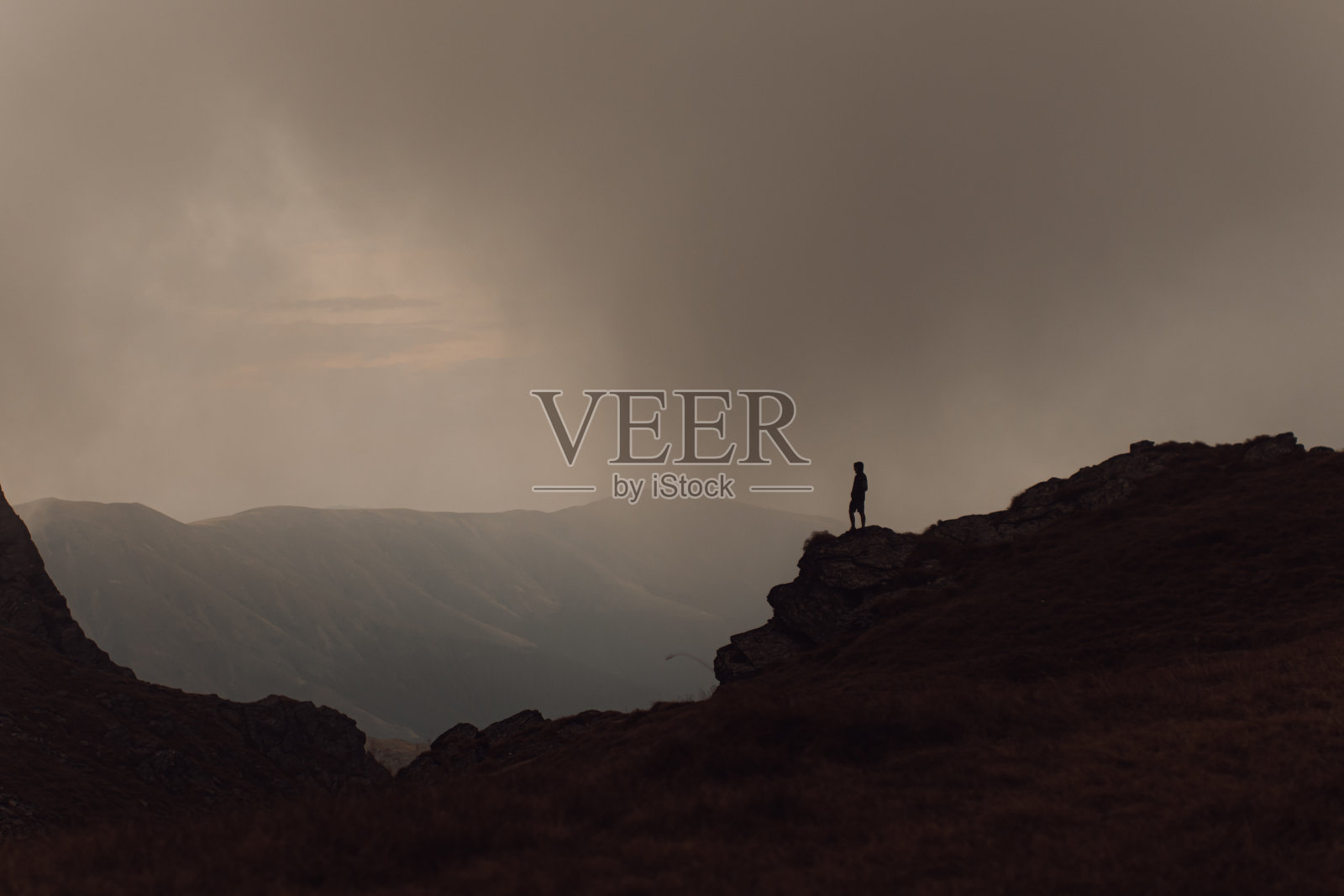 一个人的剪影站在一个高岩石形成和观察的观点照片摄影图片