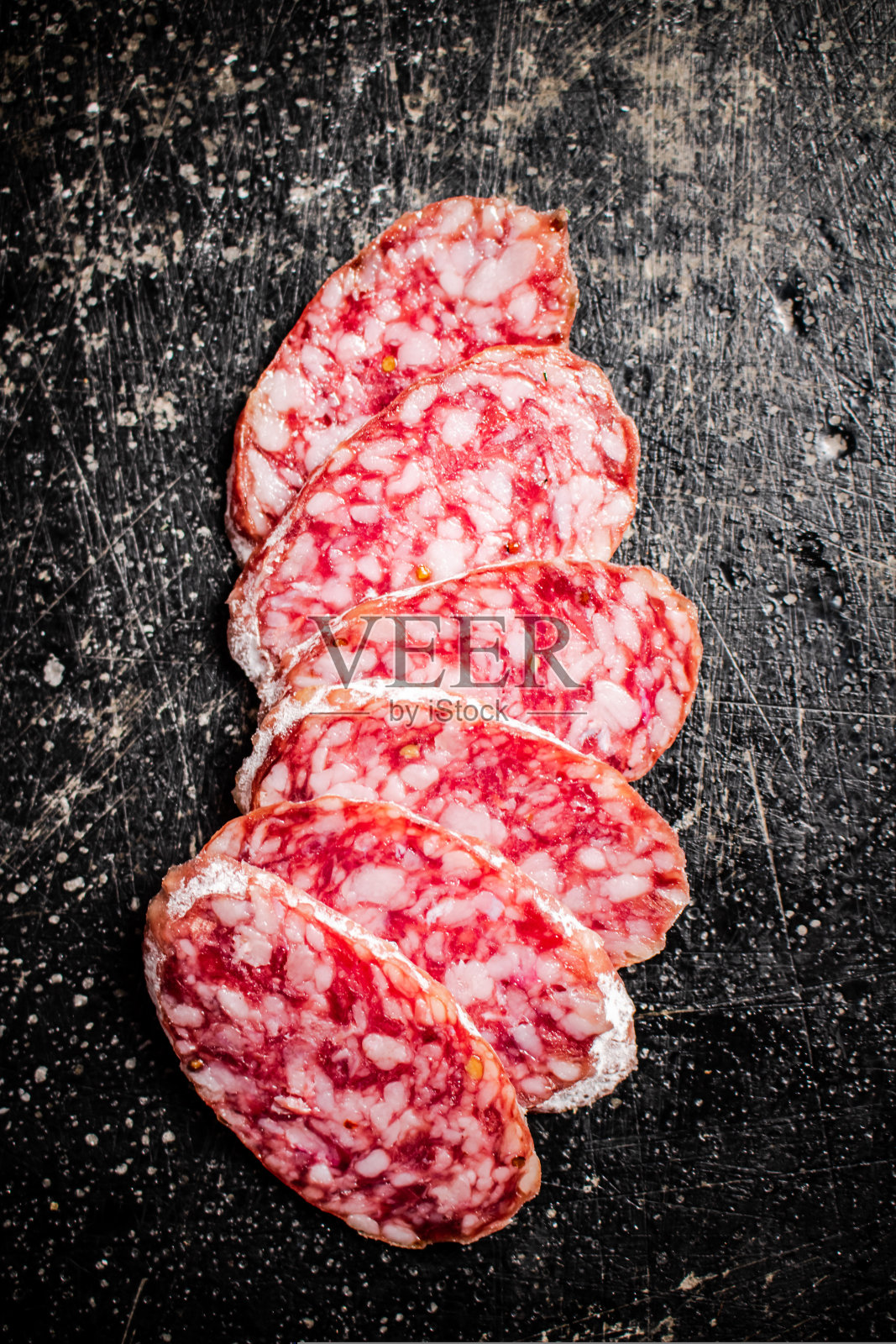 切片美味的意大利腊肠。在黑色背景上。照片摄影图片