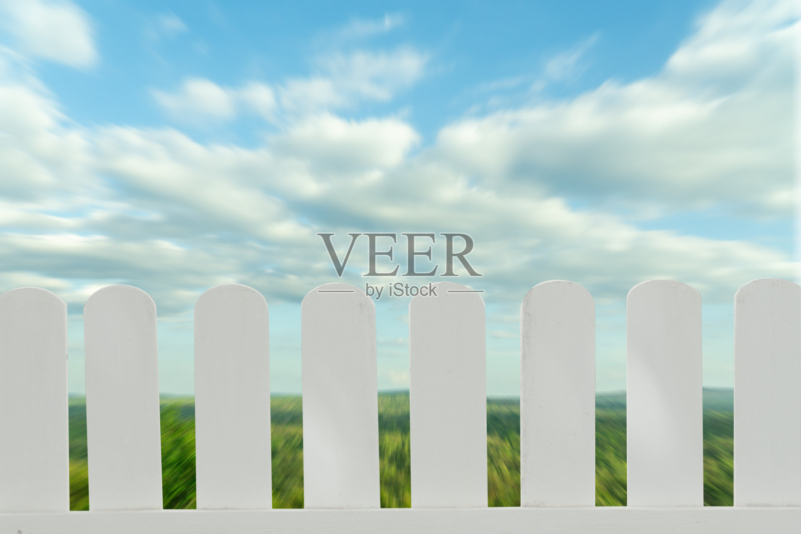 白色木栅栏孤立在一个模糊的山和天空的背景，分开的对象。照片摄影图片