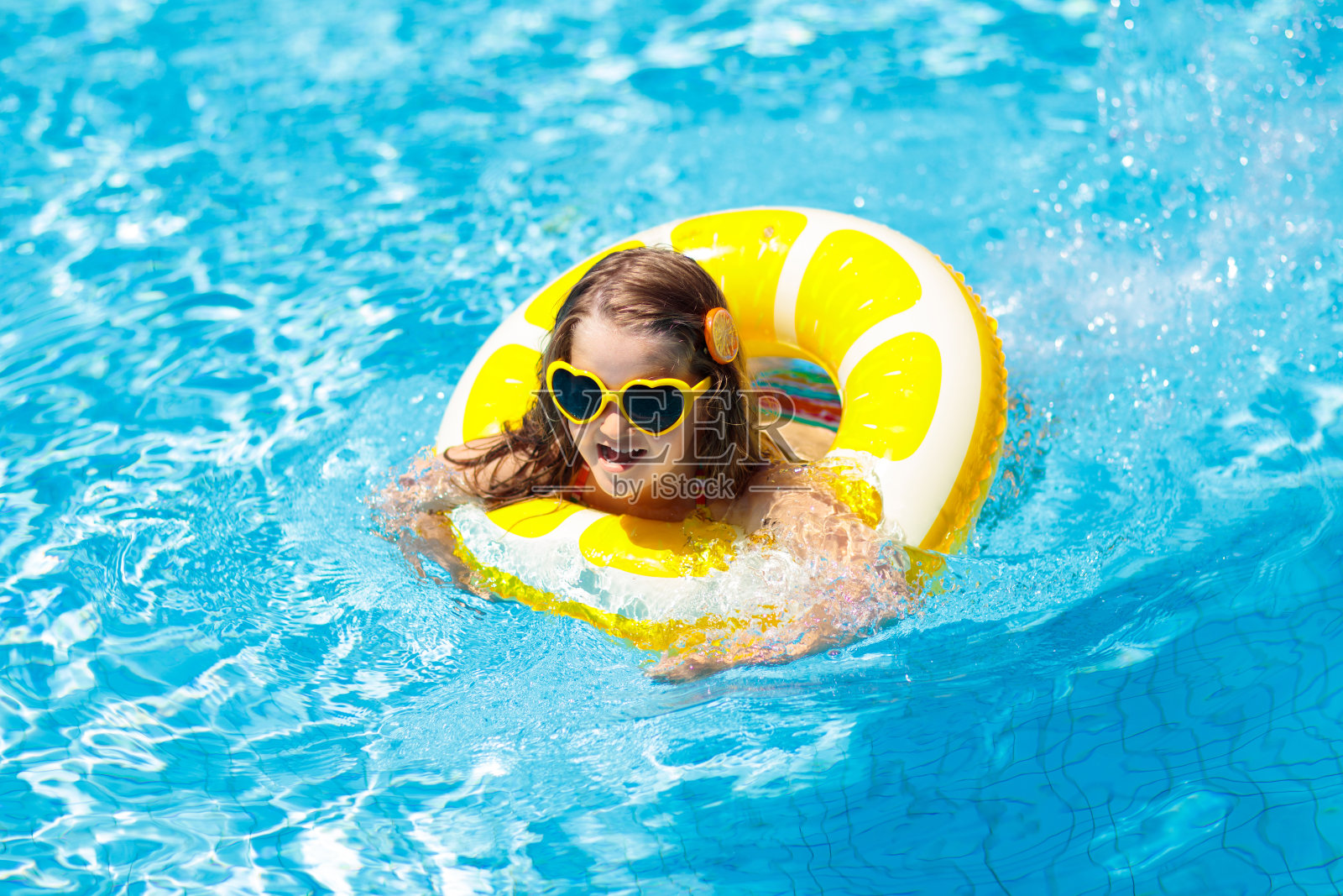 孩子在游泳池上的戒指玩具。孩子们游泳。照片摄影图片