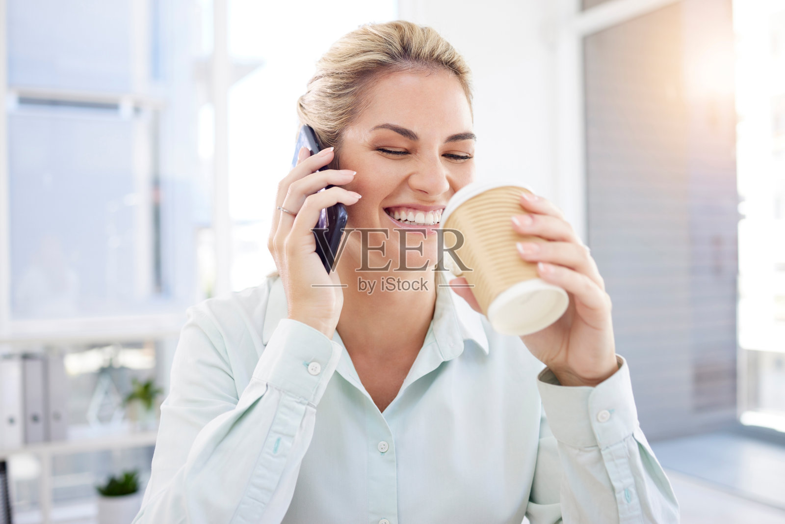 女商人，电话和咖啡在办公室，早上和快乐的微笑与有趣的谈话，沟通和镜头耀目。女员工，在工作场所喝酒和用手机聊天照片摄影图片
