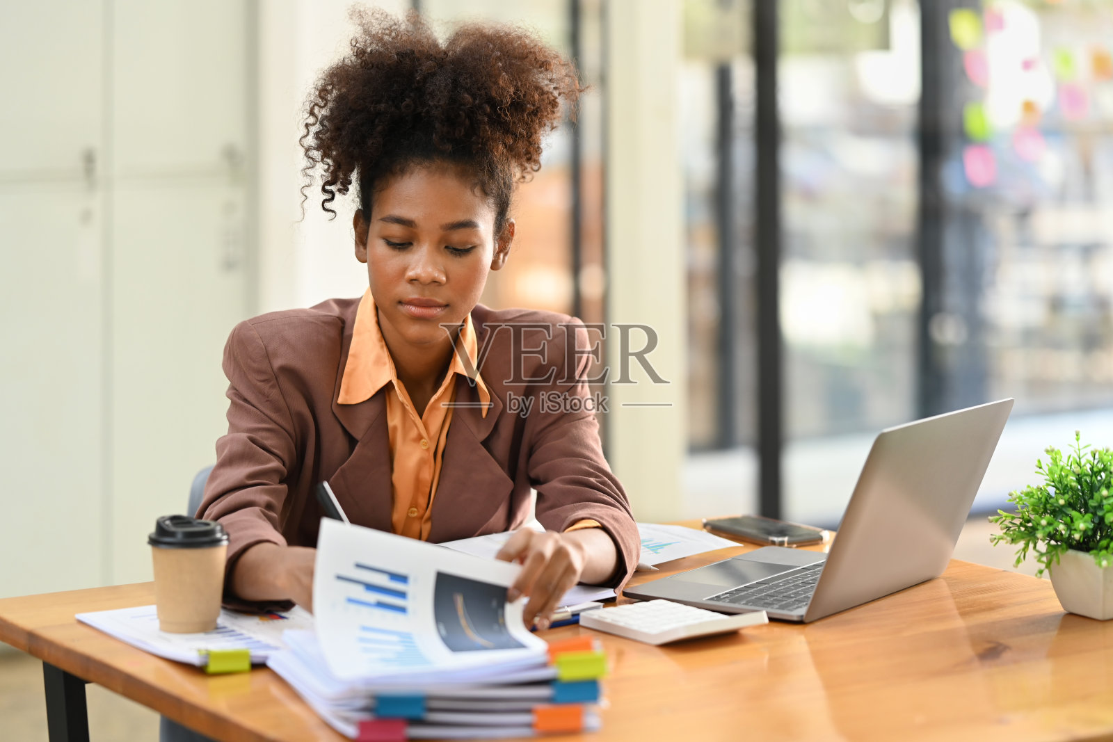美国黑人女性经济学家集中在工作台上分析金融数据并使用笔记本电脑。照片摄影图片