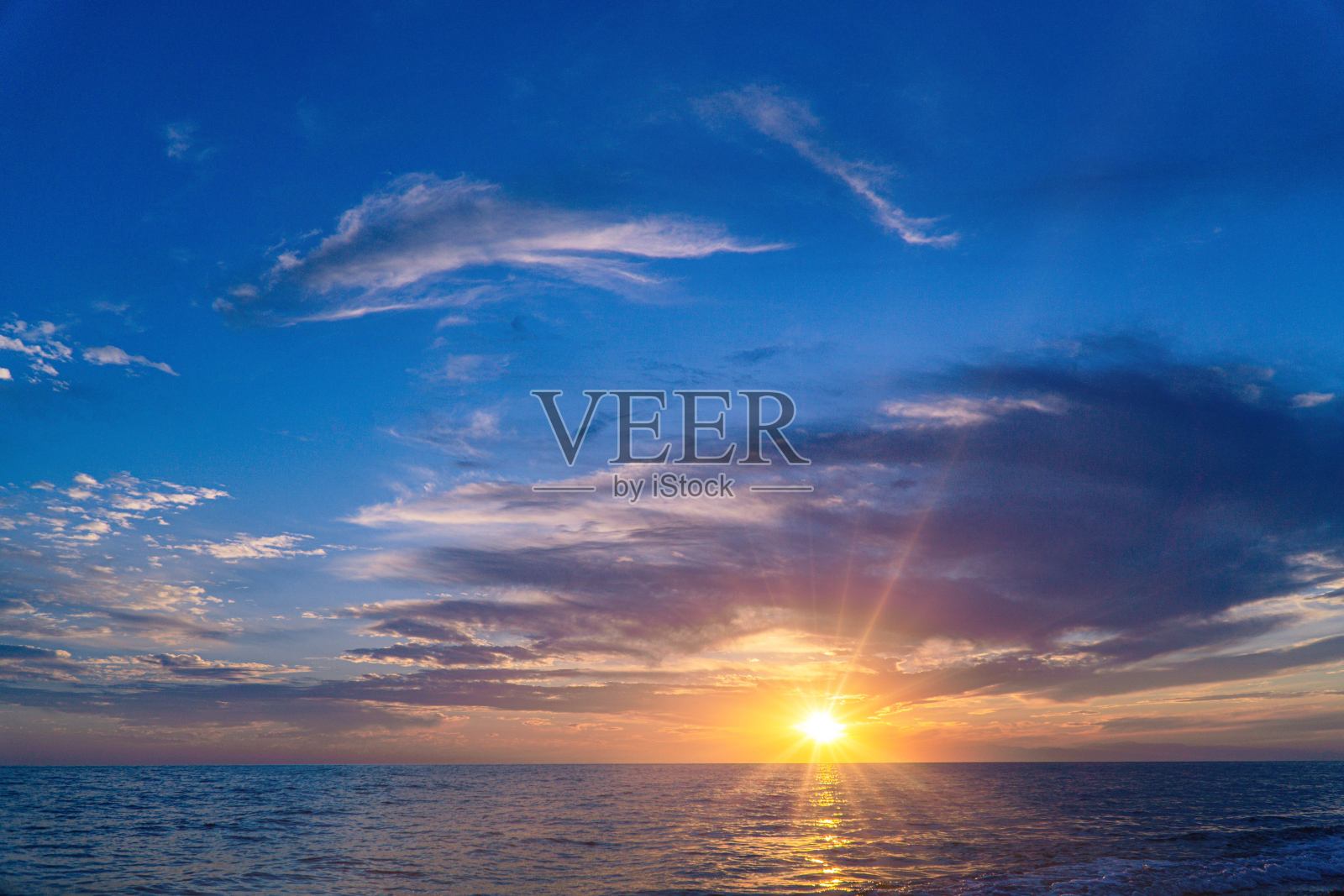 海上的日落或日出，蓝天白云倒映在水中照片摄影图片