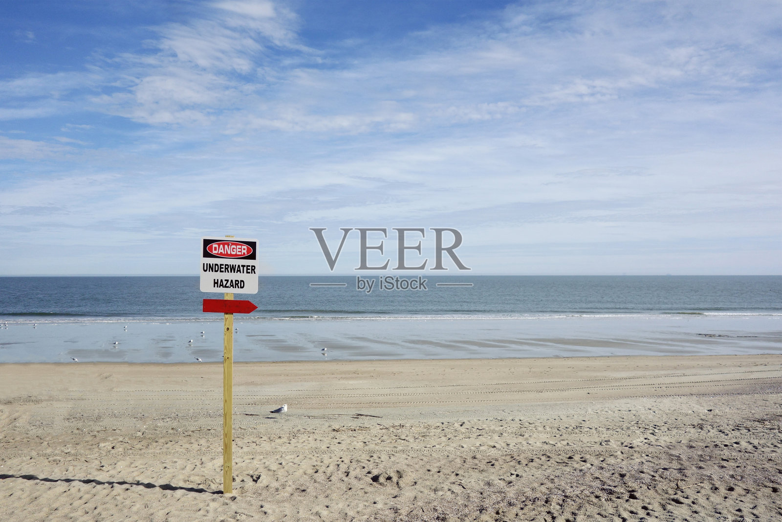 水下危险在空旷的海滩上张贴的危险标志照片摄影图片