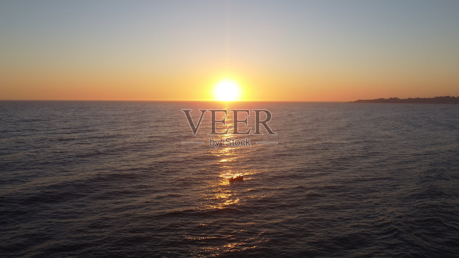 无云的日落天空和明亮的阳光反射在海水上的惊人景色照片摄影图片