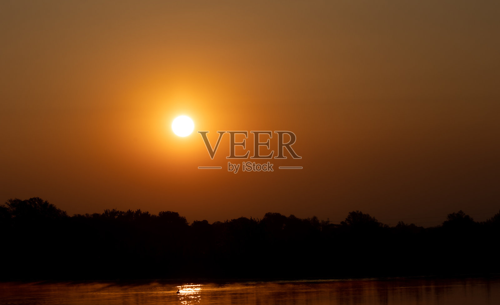 神奇的日落场景，一个孤独的金色太阳在一个湖的空天空照片摄影图片