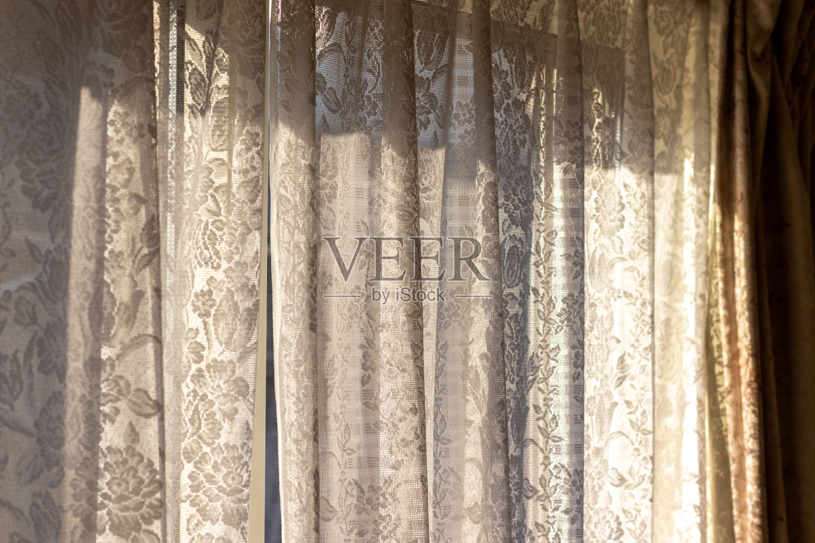 蕾丝窗帘挡住了从窗户射进来的阳光照片摄影图片