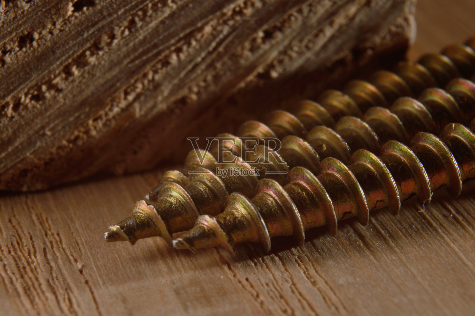 木板背景上的自攻螺丝。特写镜头。照片摄影图片