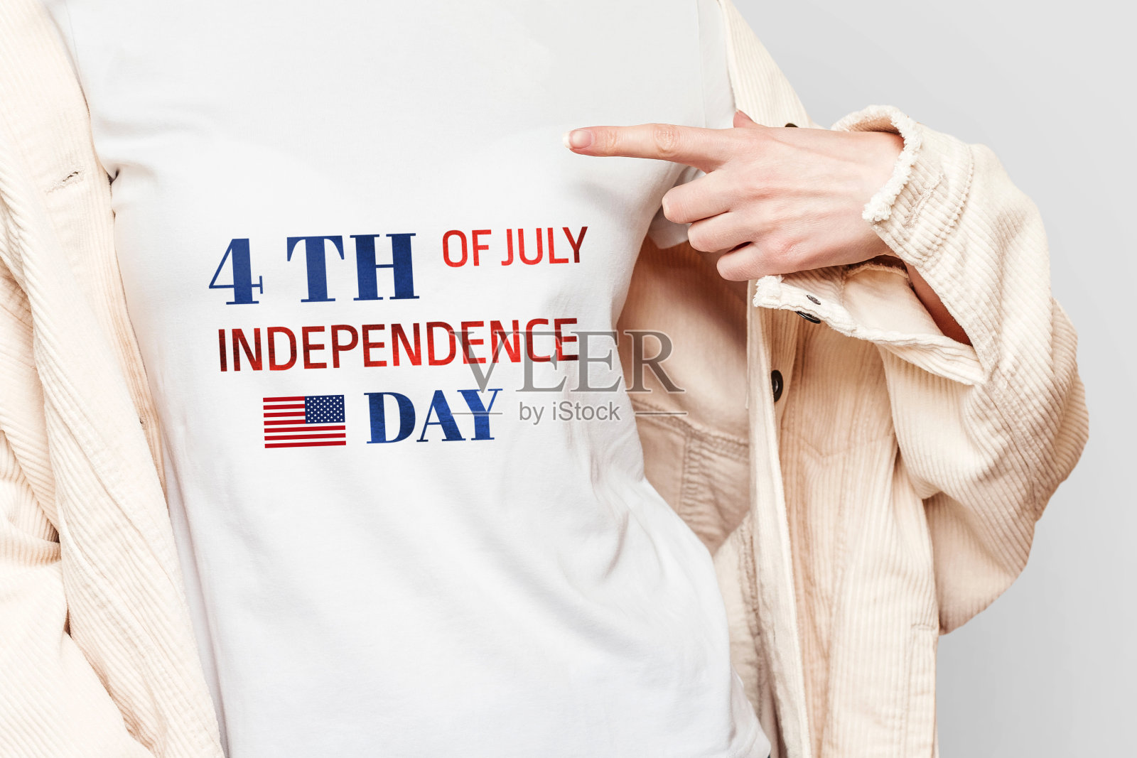 穿白t恤的女孩用手指指着文字，上面写着7月4日独立日孤立在白色背景、贺卡、海报、复制空间照片摄影图片