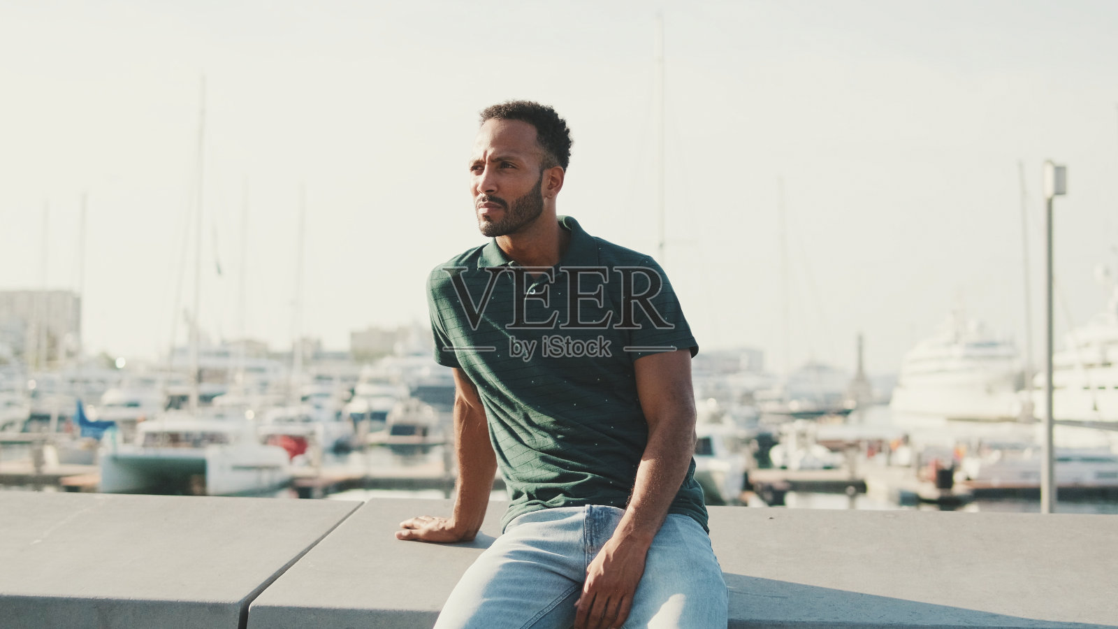 年轻人喜欢坐在港口放松，背景是游艇照片摄影图片