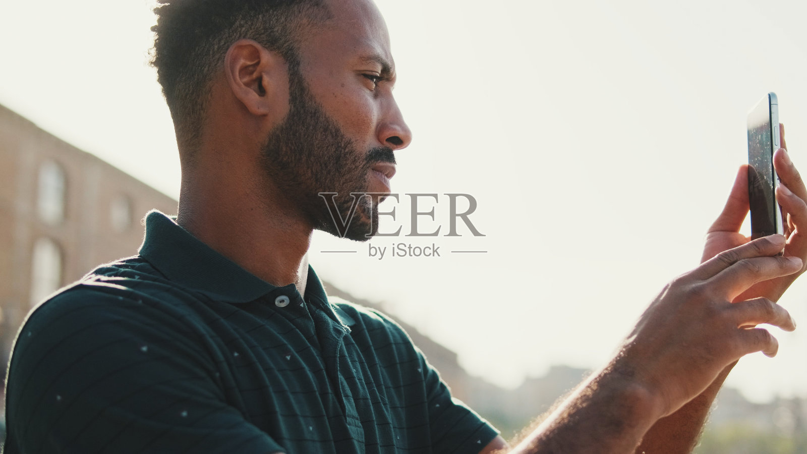 一名年轻男子在港口的智能手机游艇上拍照。照片摄影图片