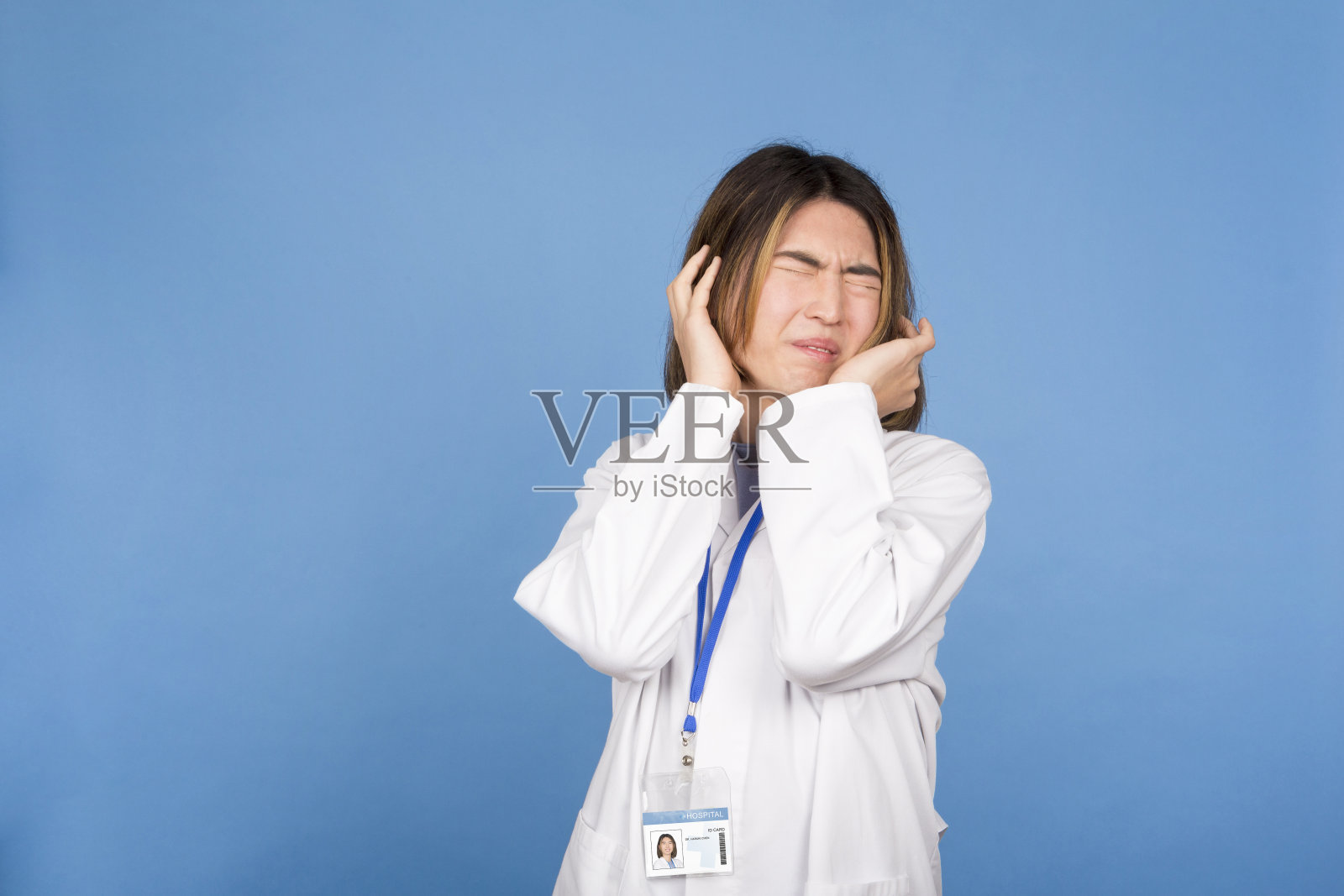 亚洲医生闭着眼睛，表情惊恐照片摄影图片