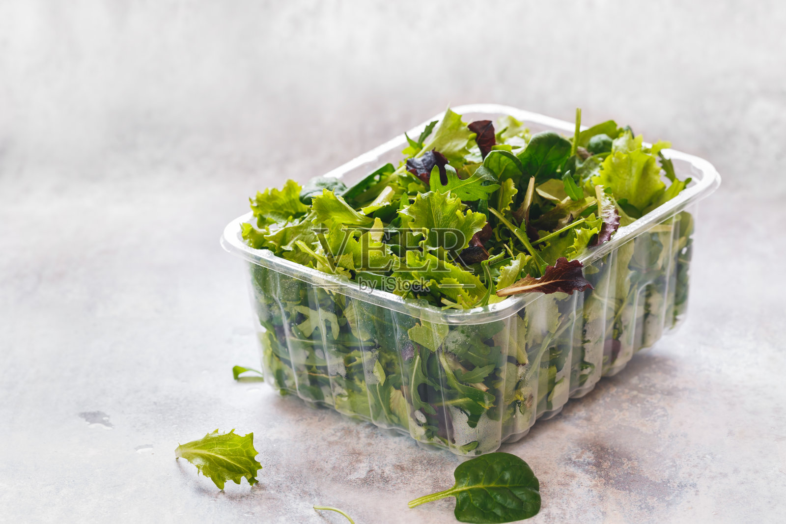 新鲜混合沙拉叶在塑料容器在乡村背景照片摄影图片