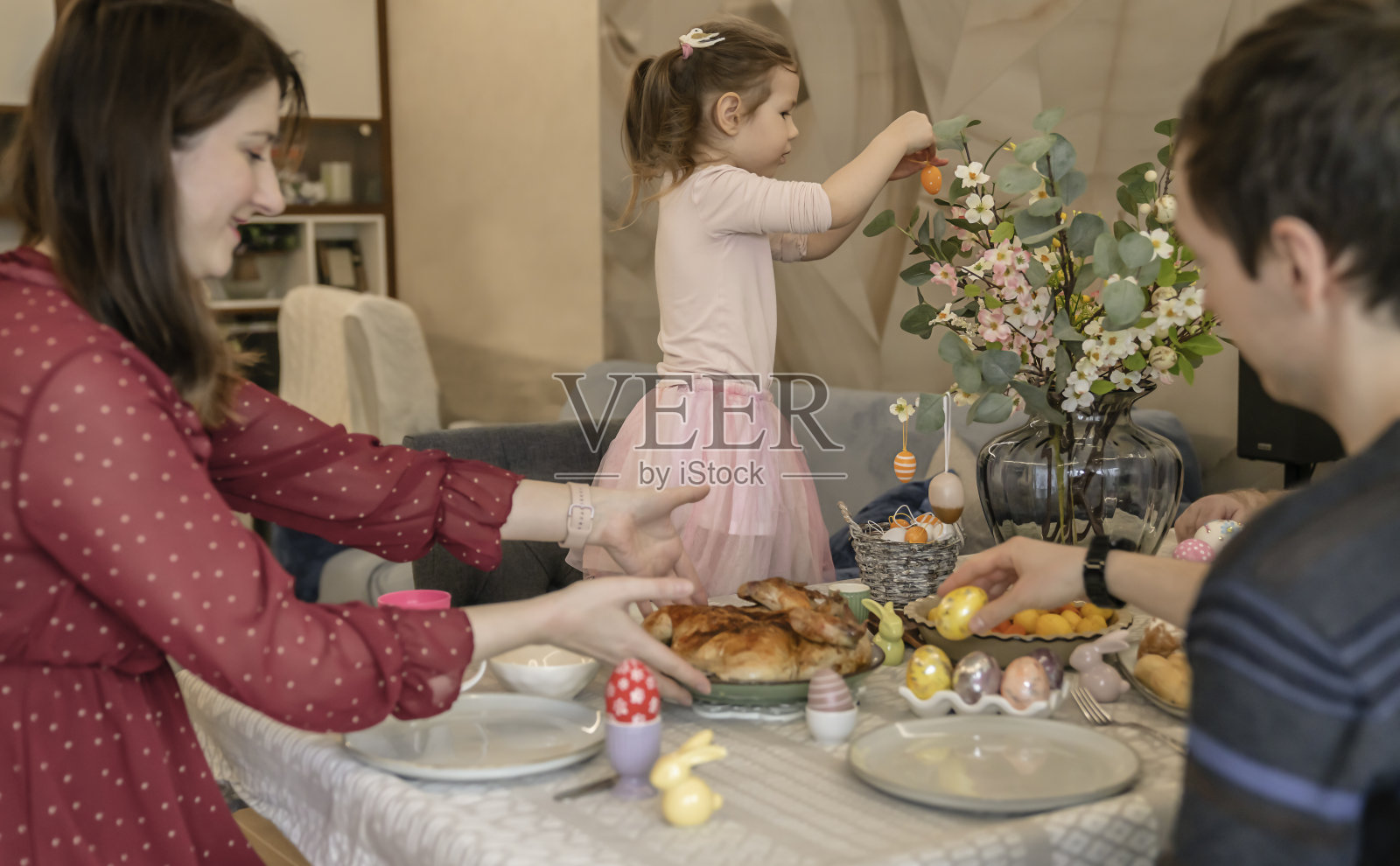 快乐的家庭在午餐时玩复活节装饰照片摄影图片