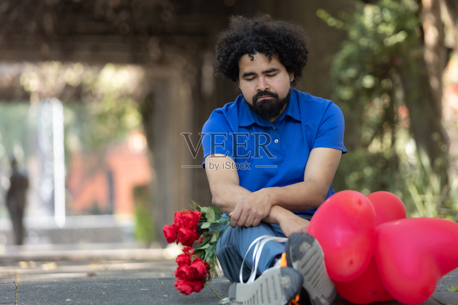 墨西哥悲伤男人坐在地板上，糟糕的约会，情人节照片摄影图片