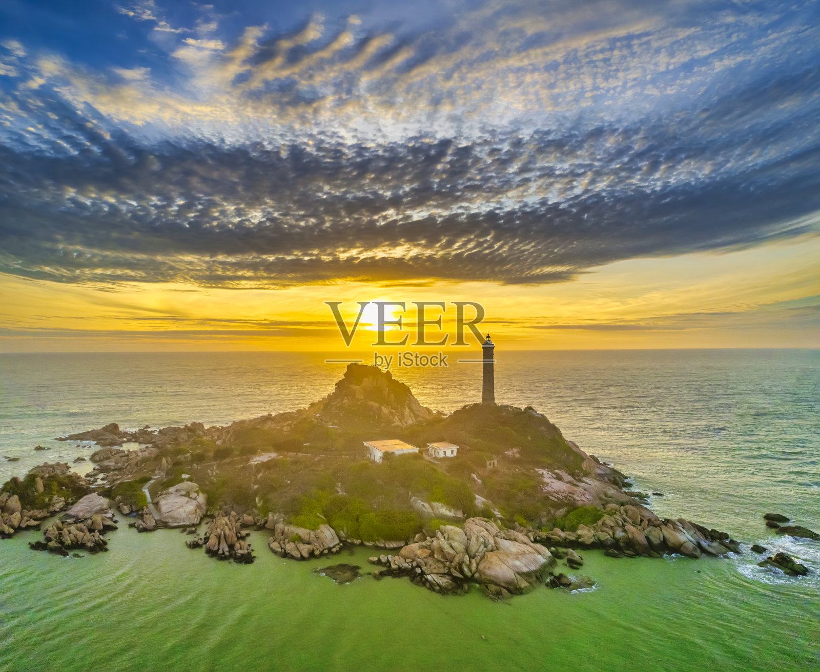 小岛景观与古老的灯塔在日出的天空照片摄影图片