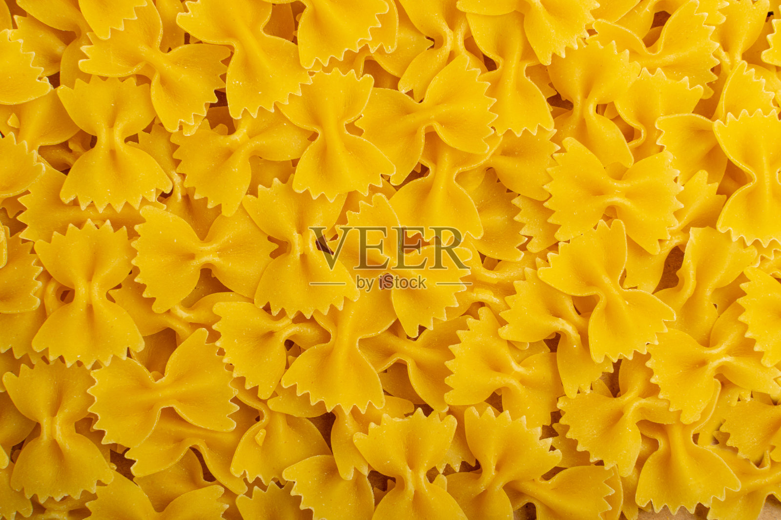 生法法尔面食纹理背景，黄色干蝴蝶面图案，小麦弓通心粉模型照片摄影图片