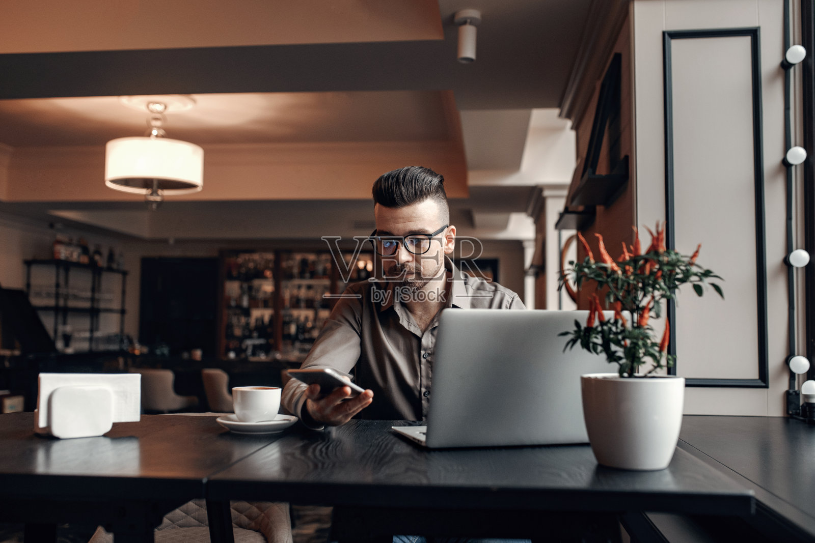 工作的商人在咖啡馆看智能手机的肖像照片摄影图片