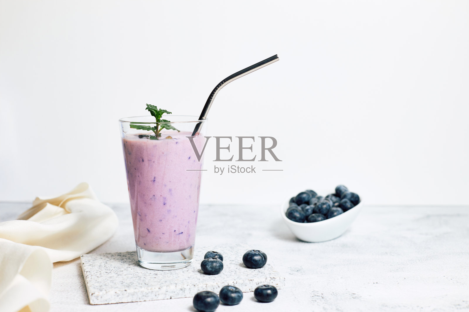 桌上有杯蓝莓奶昔。理想的素食早餐，饮食和排毒照片摄影图片