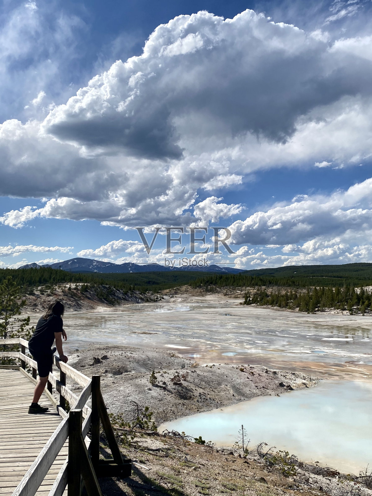 在一个阳光明媚的早晨，人们惊叹于间歇泉的景色照片摄影图片