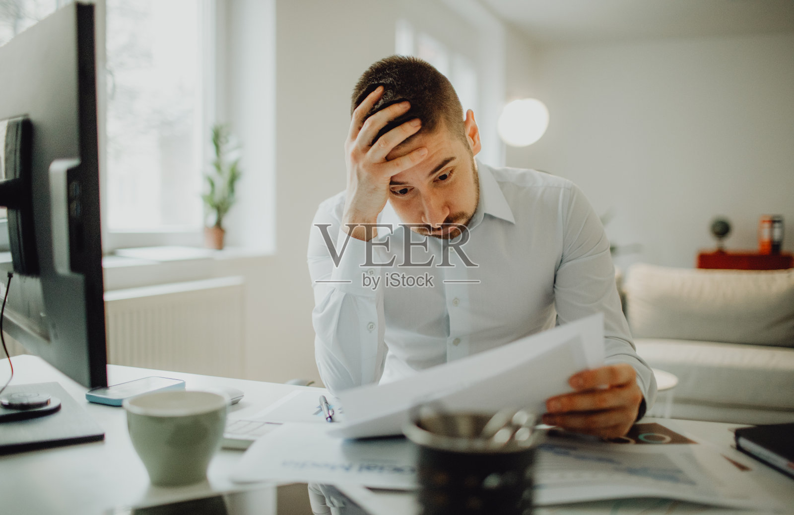 忧心忡忡的年轻商人在办公室里研究战略和文书工作照片摄影图片