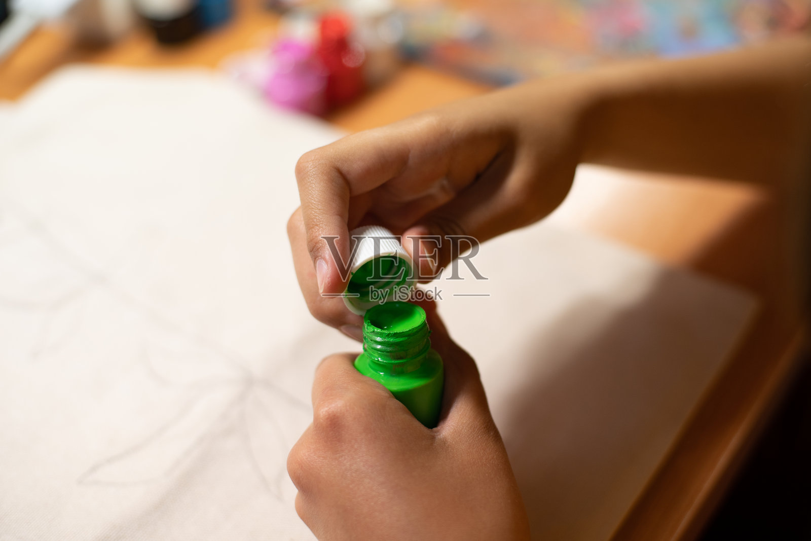 手打开绿色油漆瓶子的特写镜头照片摄影图片