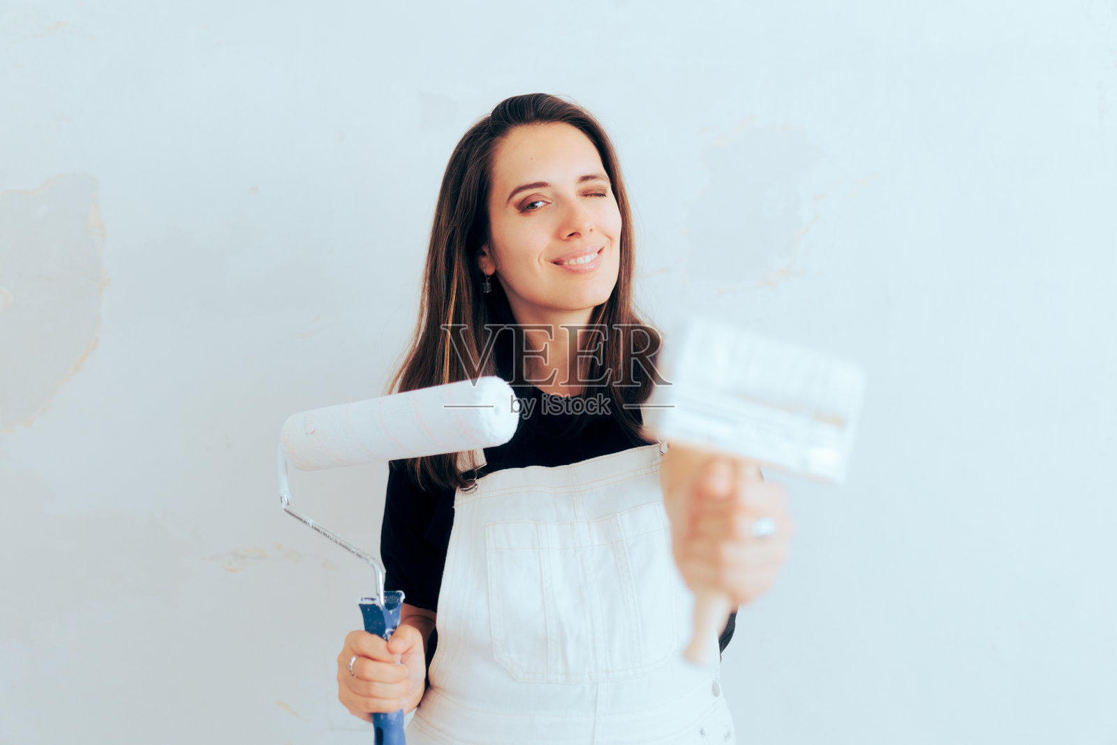 女人拿着油漆滚筒和刷子准备春季大扫除照片摄影图片