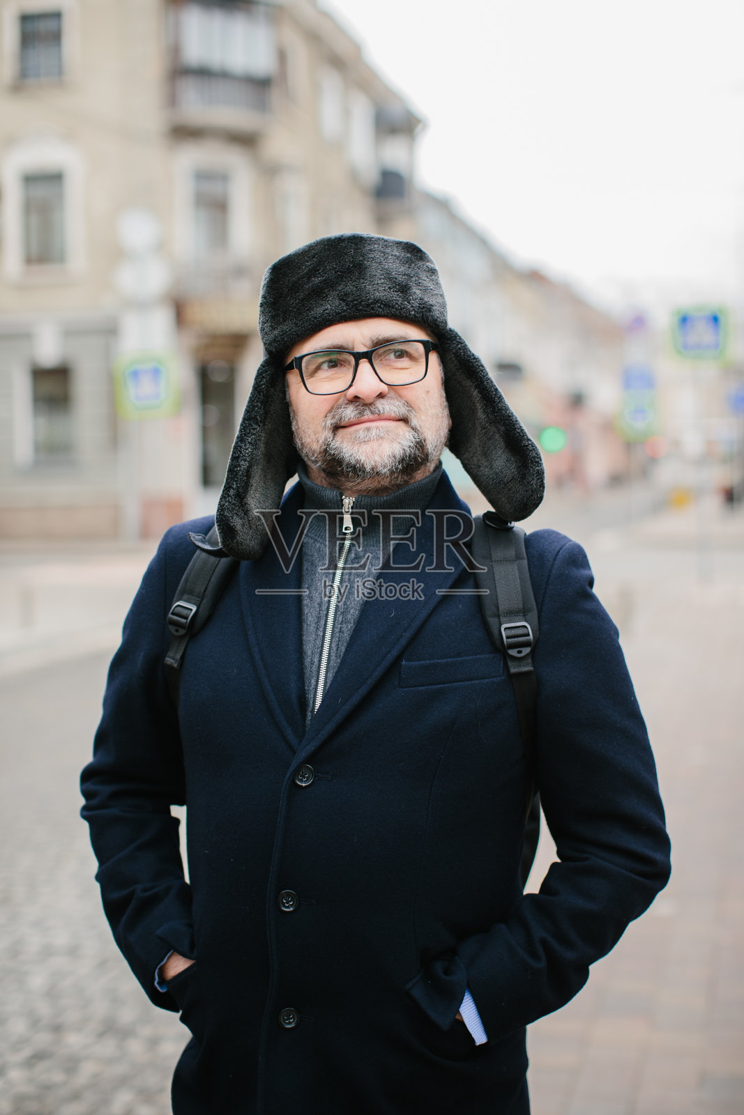 周末，老人在冬城散步。城市生活和娱乐的概念。照片摄影图片