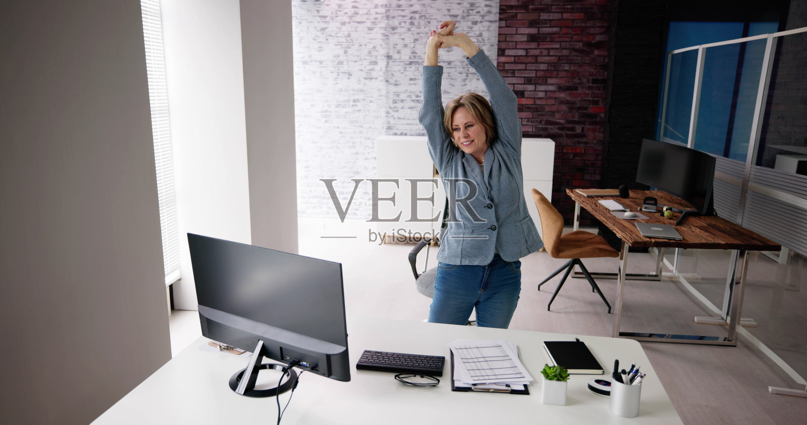 站在桌子旁伸展手臂照片摄影图片