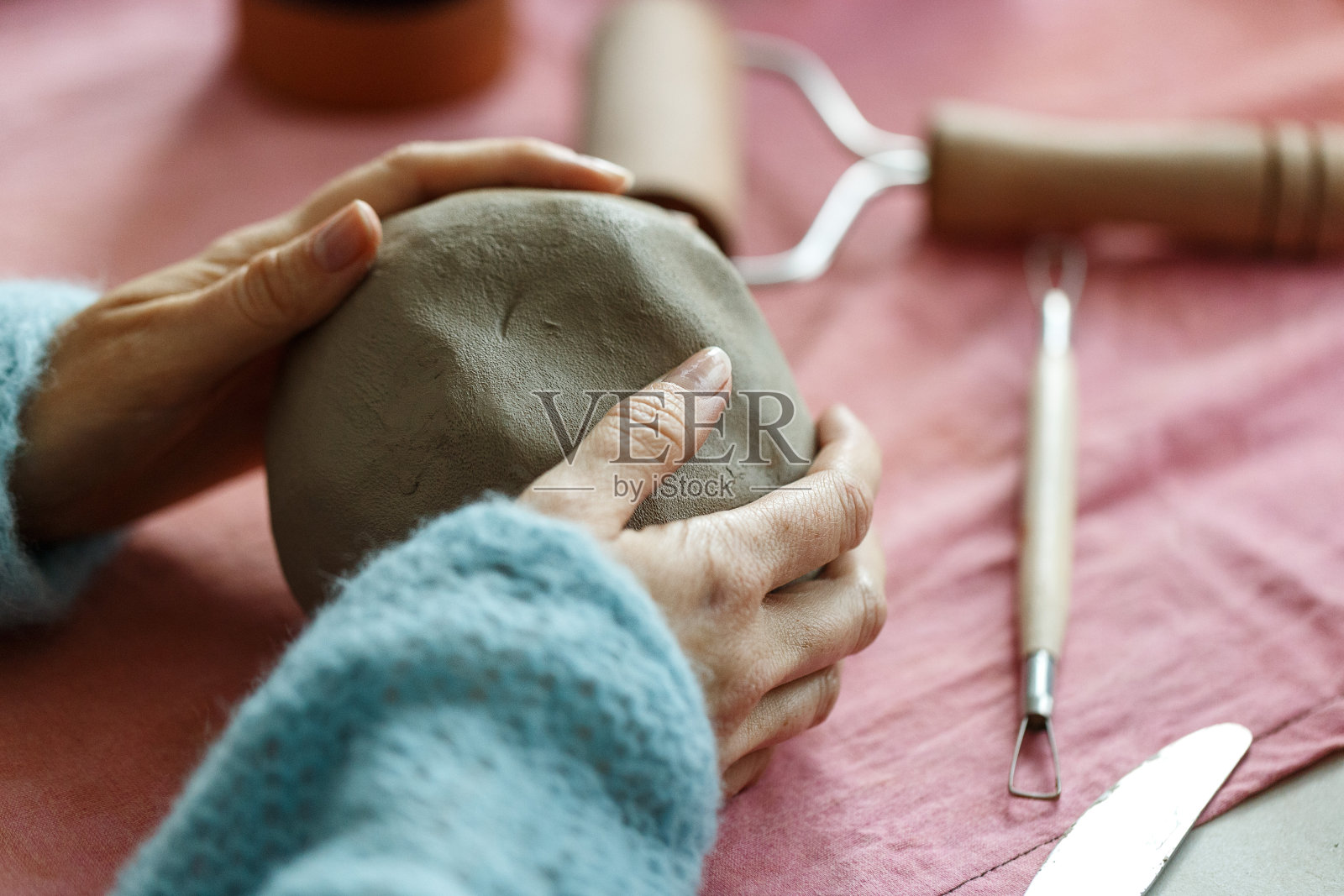 女陶艺艺术家准备陶土成型。近距离观看女人的手与粘土。创意手工工艺。陶瓷工作室照片摄影图片