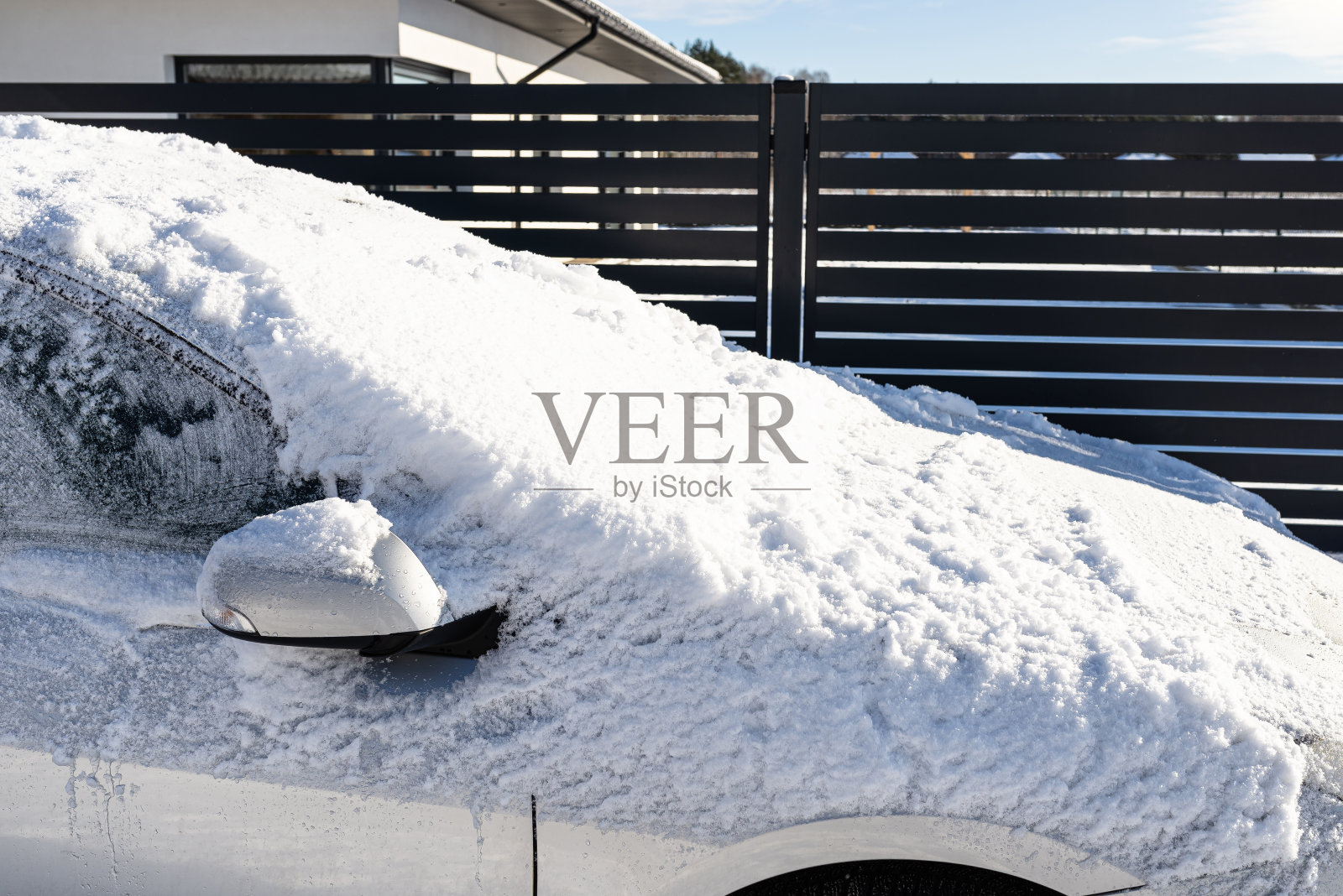 一辆旅行车站在覆盖着冰雪的镶板栅栏前。照片摄影图片