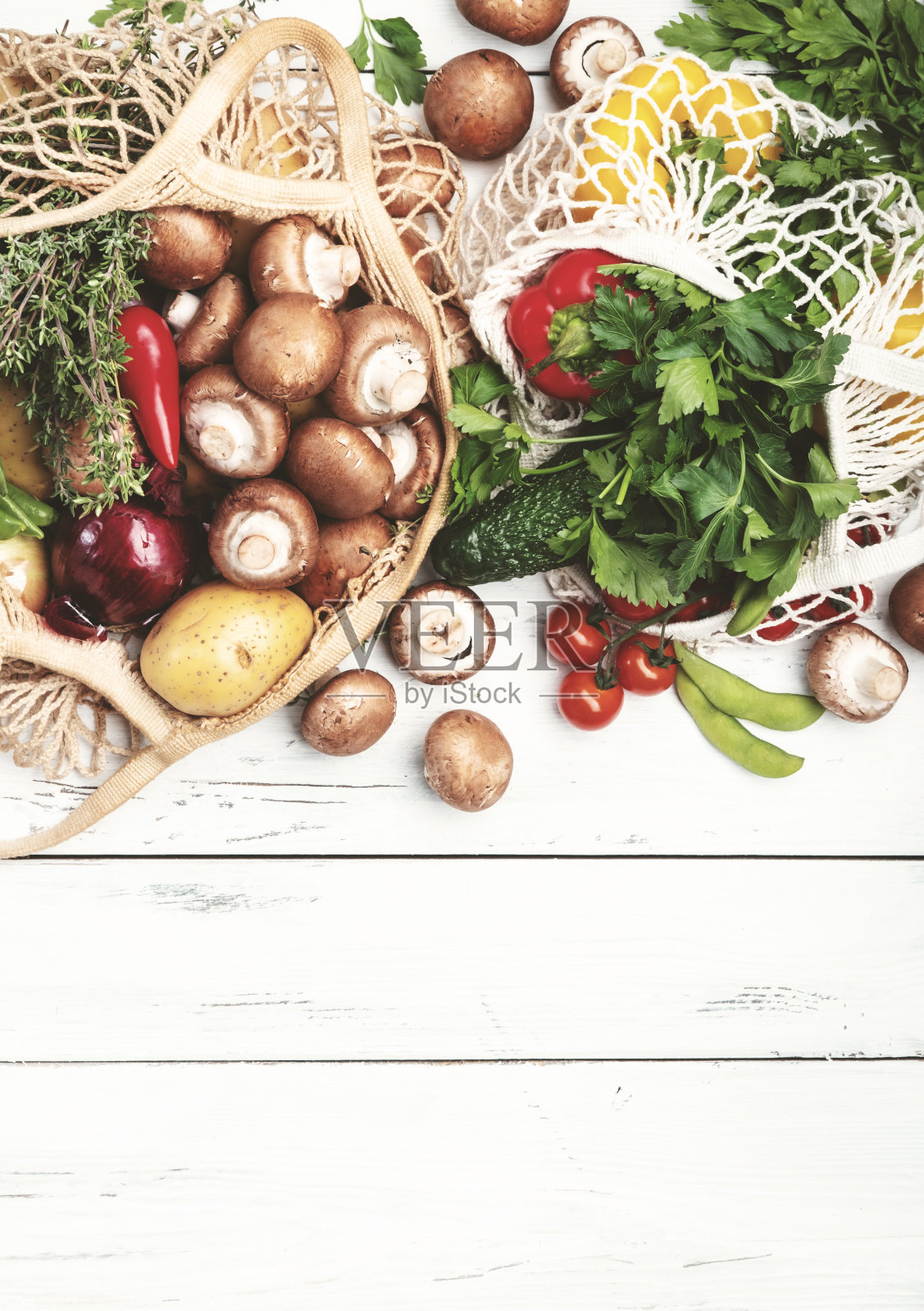 健康食物选择:蘑菇、豆类、西红柿、牛油果和草药。可重复使用的购物纺织袋装满了当地农贸市场的有机春季蔬菜。前视图。可持续的零废物生活方式概念照片摄影图片