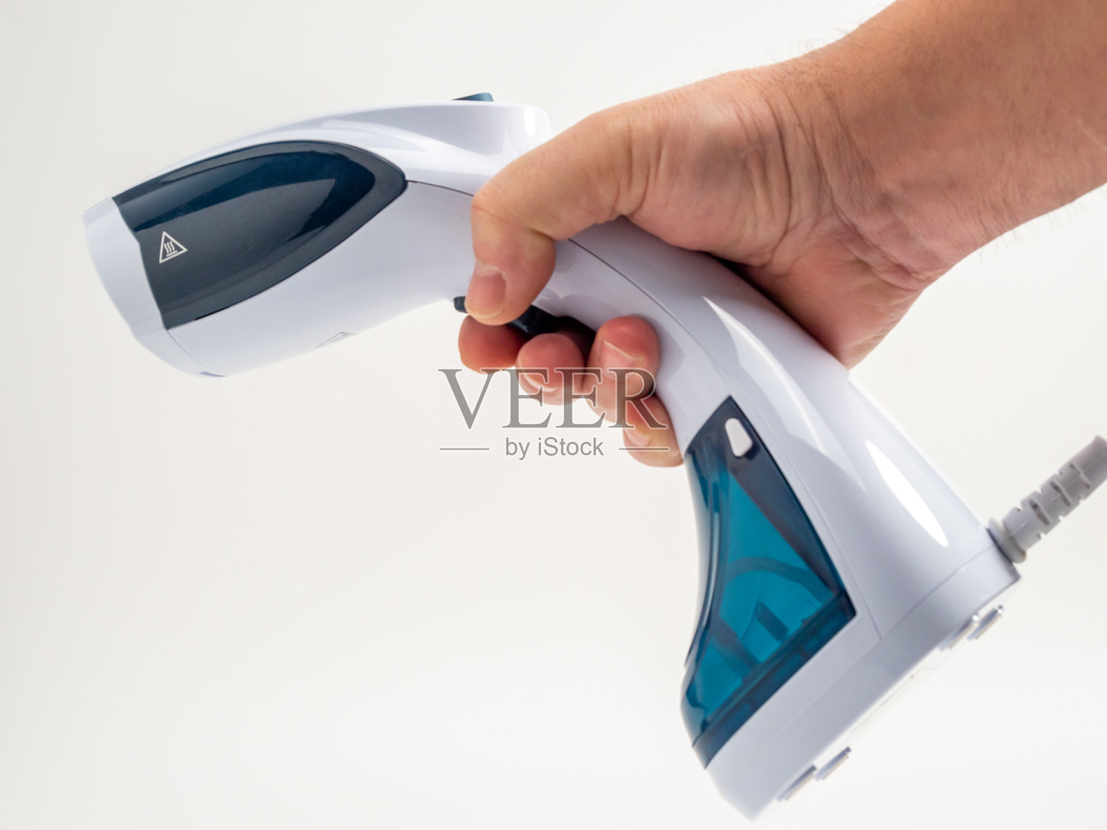 手工蒸笼，用于白色背景上的衣服。便携式铁。照片摄影图片