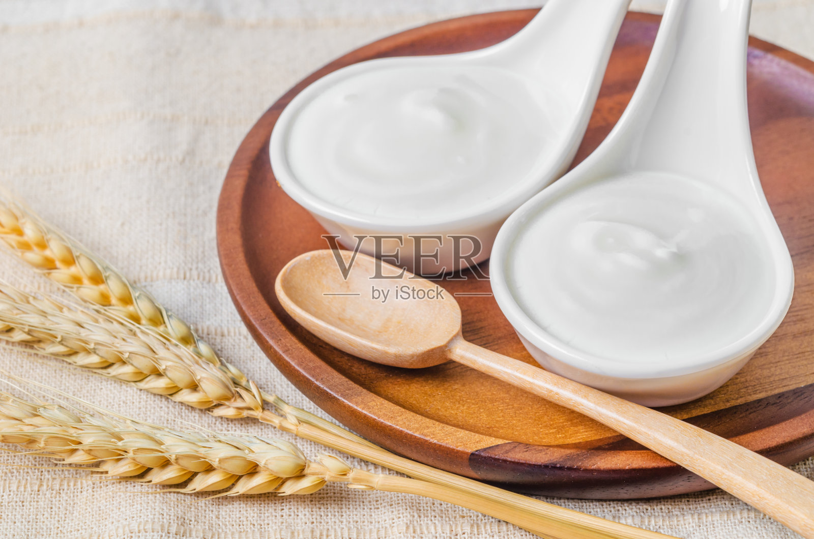 希腊酸奶放在碗里，干大麦放在桌布上。照片摄影图片