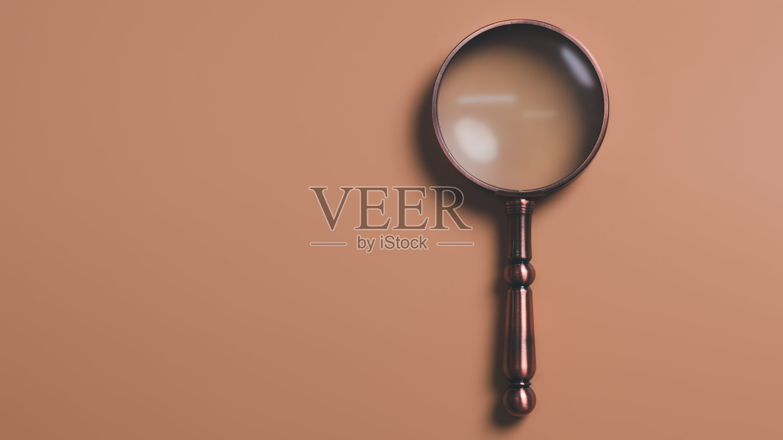 一个放大镜放在橙色的背景上，信息搜索概念，进行研究，从学习和研究中获取知识，搜索引擎优化。照片摄影图片