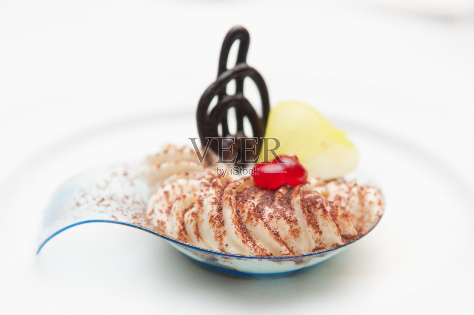 白色盘子上的奶油甜点和可可粉的特写镜头照片摄影图片