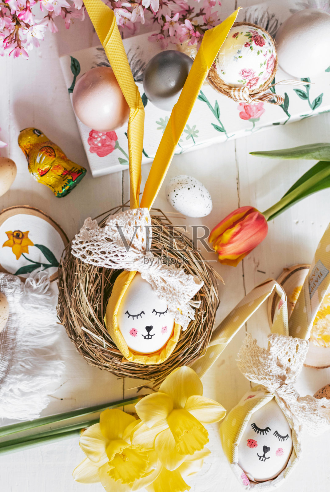 顶部视图的复活节节日装饰，食物，鸡蛋在白色的木制背景。花，兔子，窝。照片摄影图片