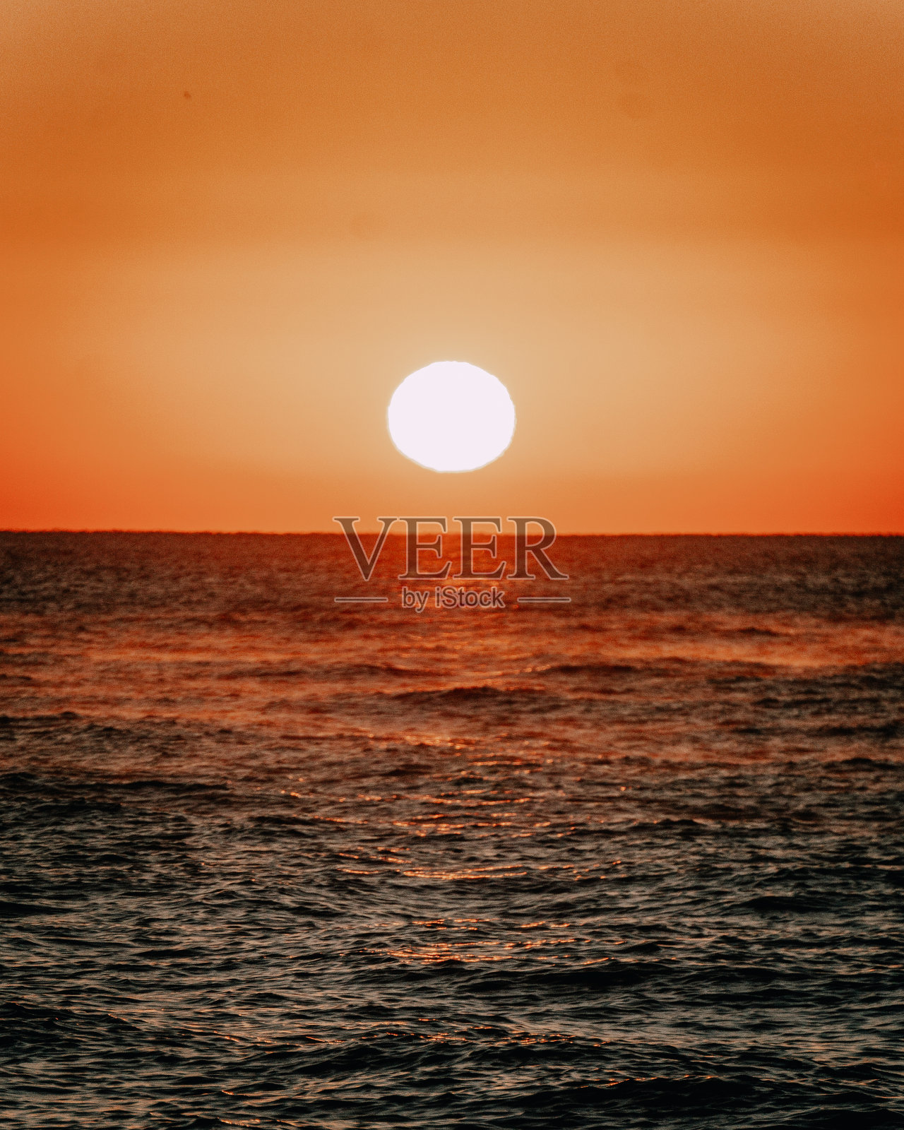 垂直拍摄的海洋在阳光下，在一个美丽的日落在傍晚照片摄影图片