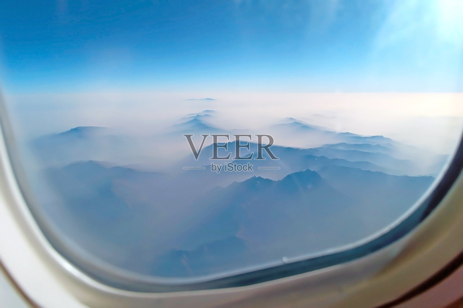 从飞机窗口看到的山脊上的美丽景色，清晨的云和蓝天照片摄影图片