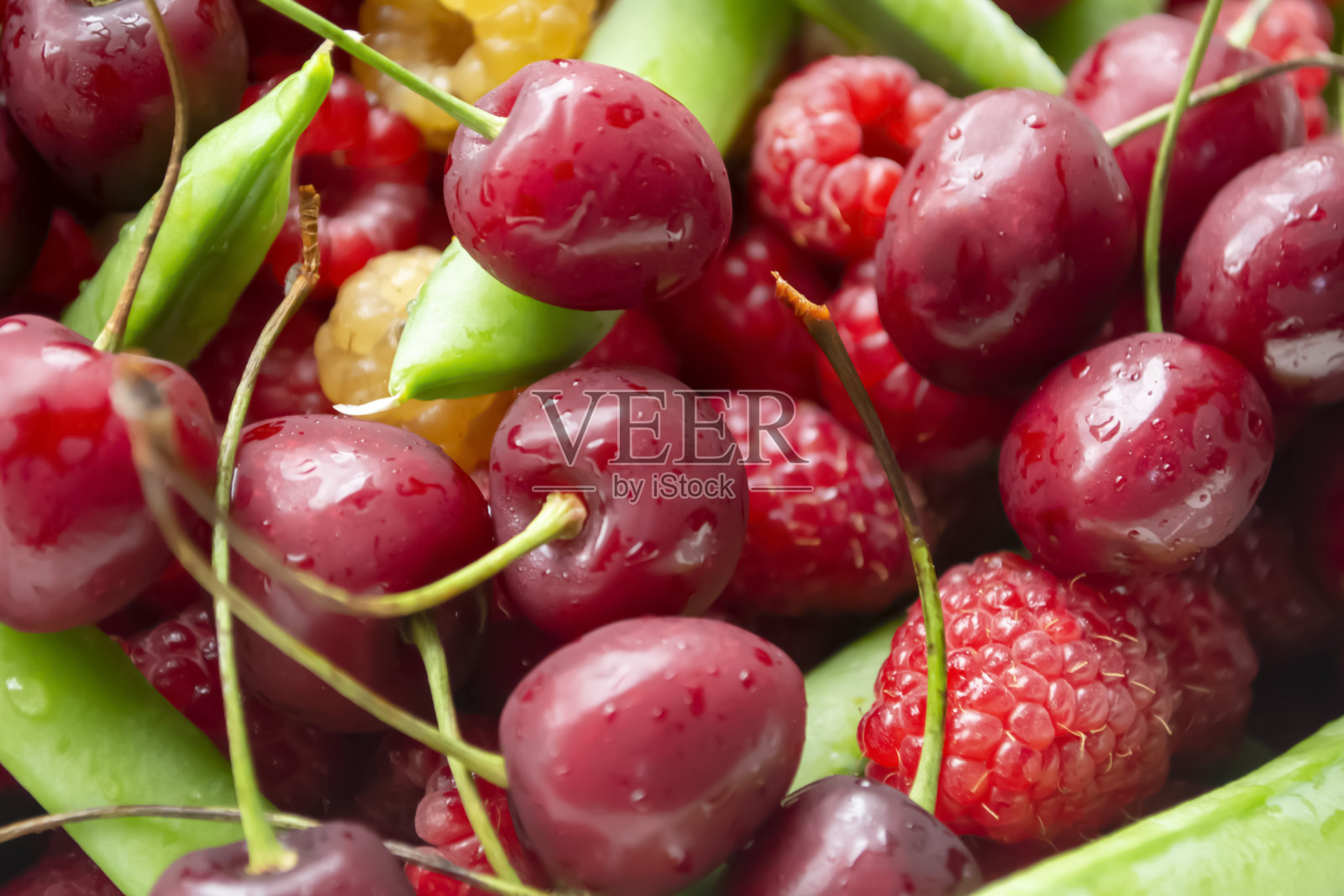 樱桃，覆盆子和绿豌豆。浆果的背景照片。夏季浆果——樱桃，绿豌豆和覆盆子。照片摄影图片