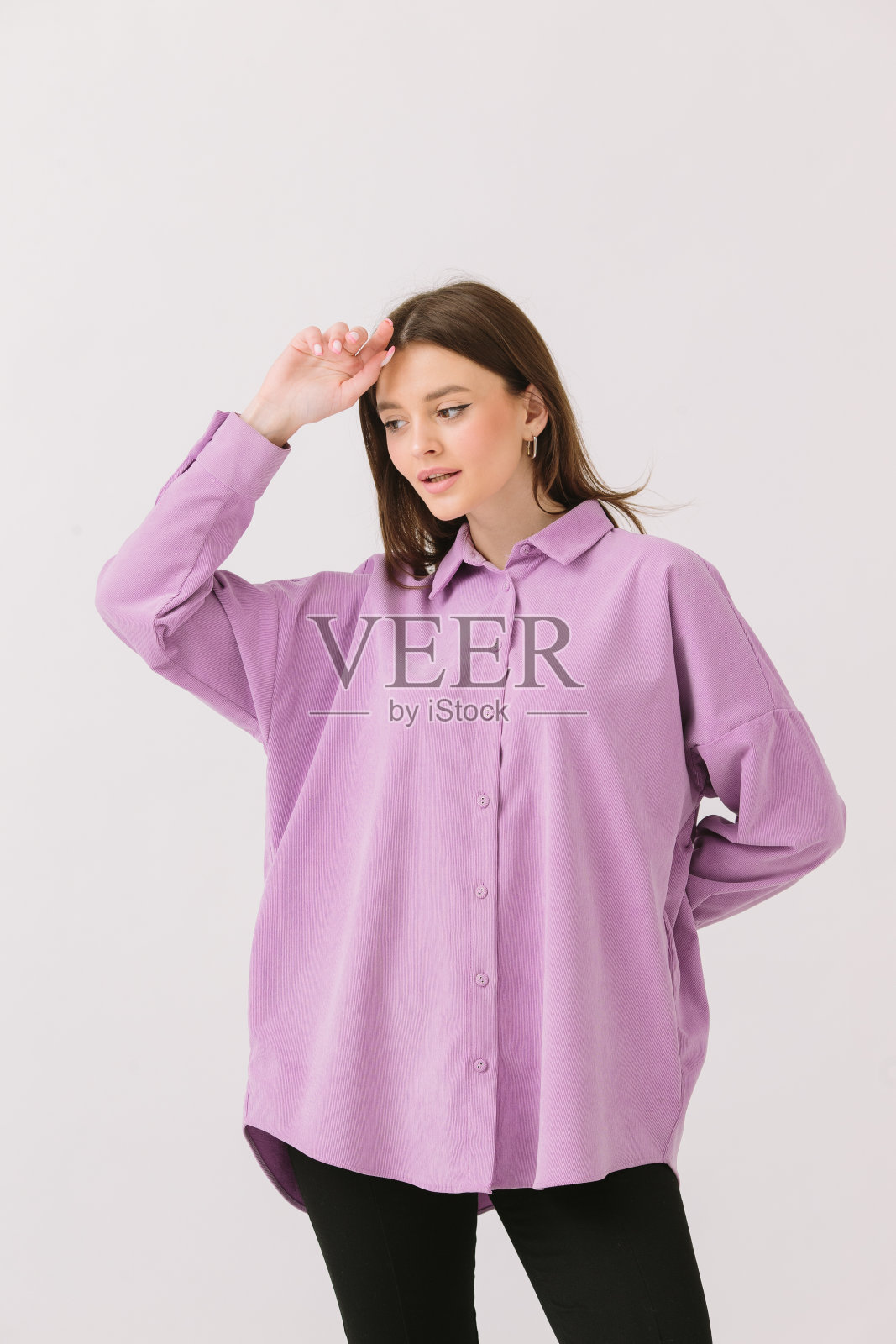 照片的一个美丽的黑发女人在彩色紫色衬衫孤立的白色背景。衬衫模型。照片摄影图片