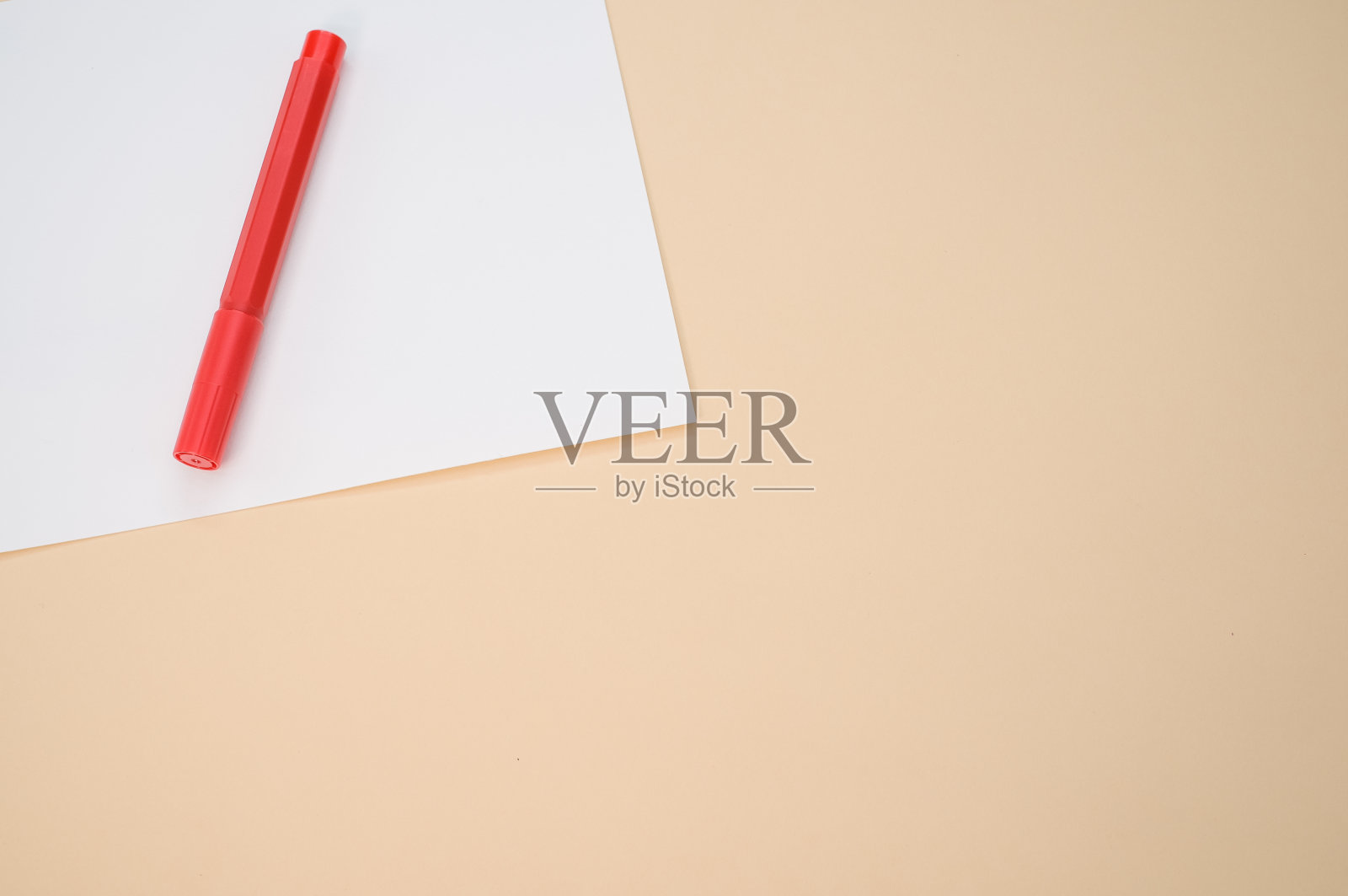 特写镜头的一个红色标记与白纸孤立在粉红色背景与复制空间照片摄影图片