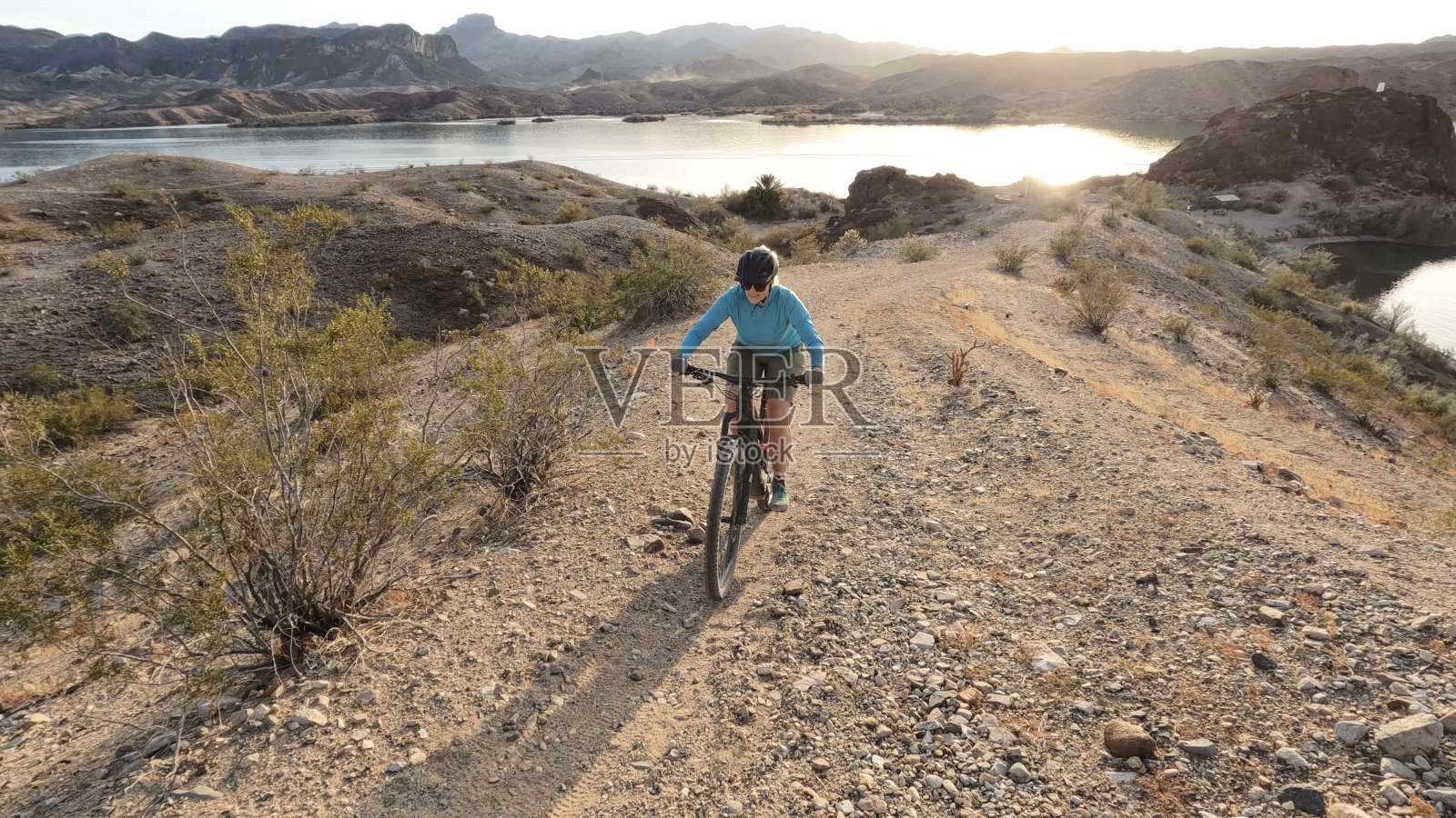 成熟女子电动山地车在沙漠小径照片摄影图片