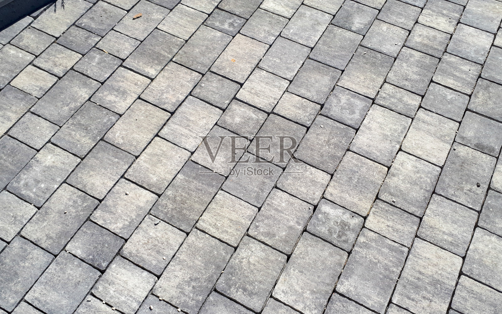 灰色的铺路石。铺装路面。纹理由大的灰色水泥砖制成。砖石街道路面纹理效果照片摄影图片