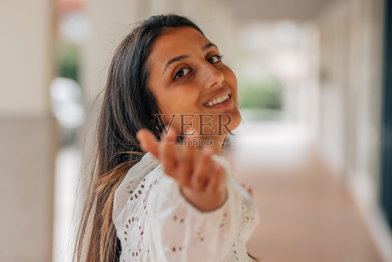 拉丁美洲女孩在街上微笑与手照片摄影图片