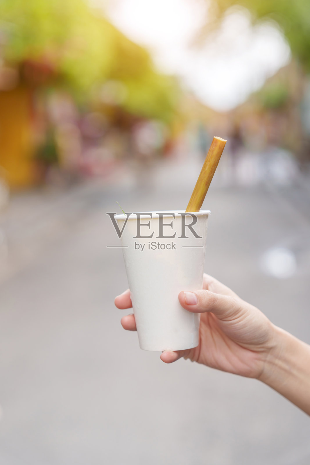 在越南中部的会安古镇，最受游客欢迎的饮料是用荷花和茶叶制成的手捧纸杯照片摄影图片