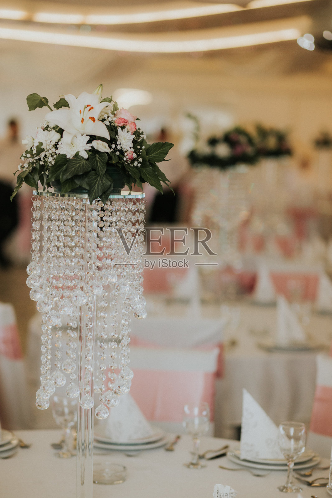 花被插在漂亮的花瓶里，上面挂着水晶;婚礼装饰创意照片摄影图片