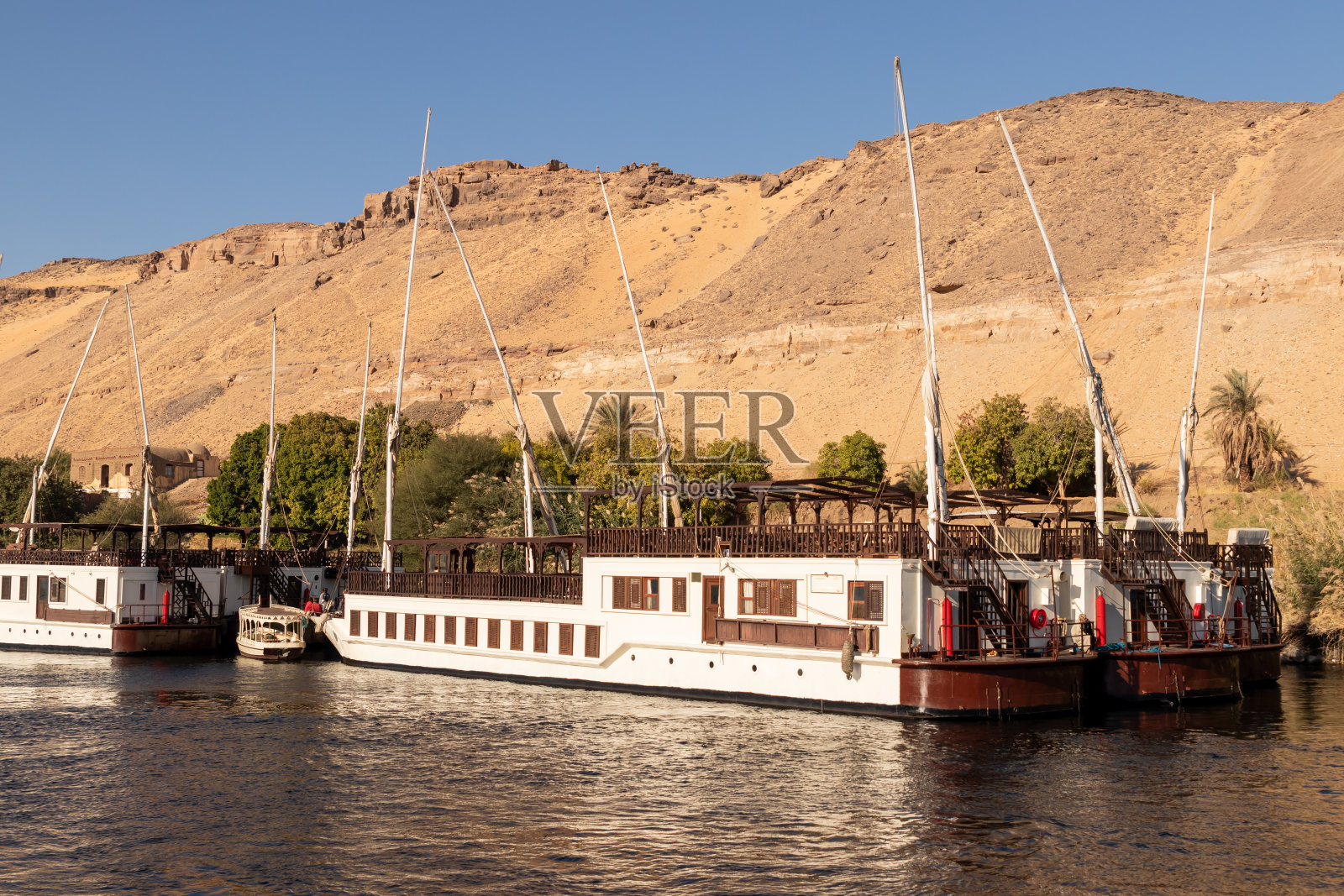 大量的传统木船停靠在沙丘景观的背景照片摄影图片